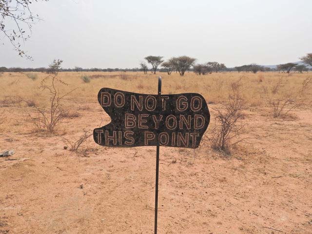 Pancarte dans le désert qui interdit d'aller plus loin. Elle symbolise selon Anne Craye la résistance au changement en entreprise